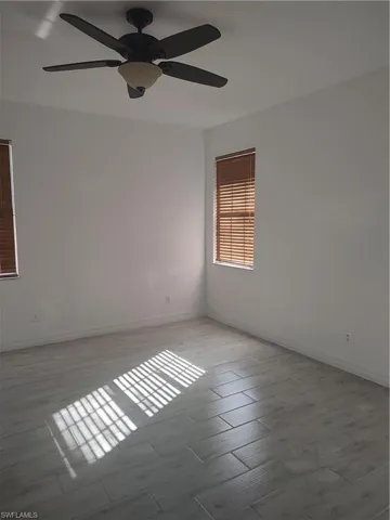 Empty room with a ceiling fan and light wood-style floors