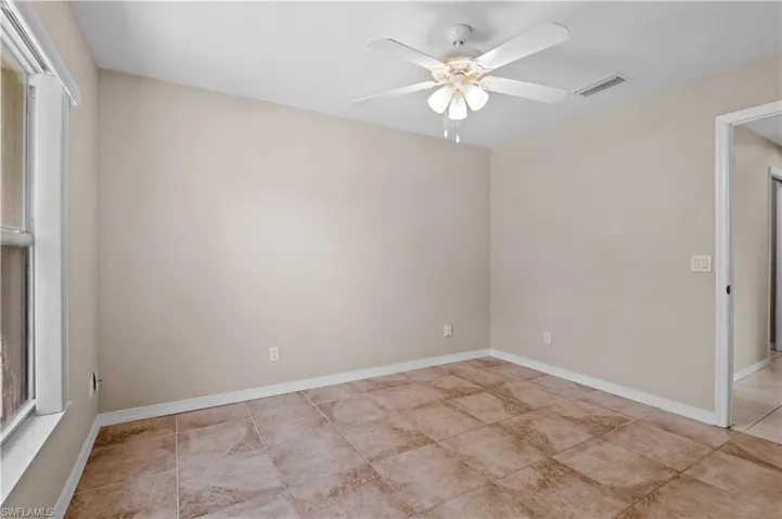 Unfurnished room with ceiling fan and light tile patterned floors