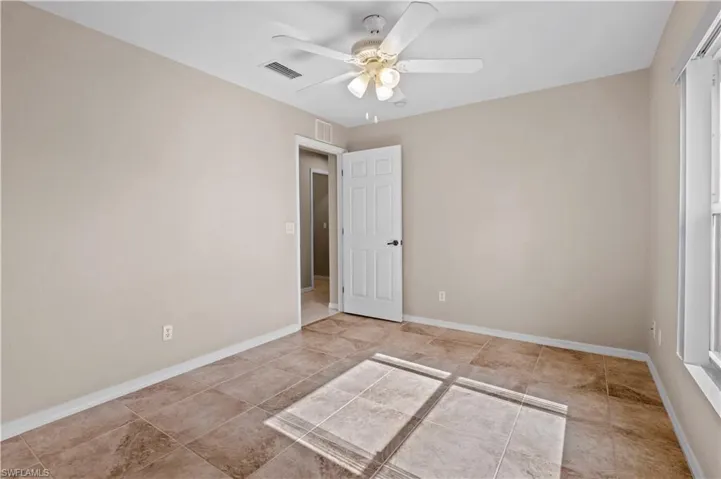 Spare room with ceiling fan and light tile patterned floors
