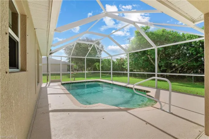 View of pool featuring a patio area, a lanai, and a lawn