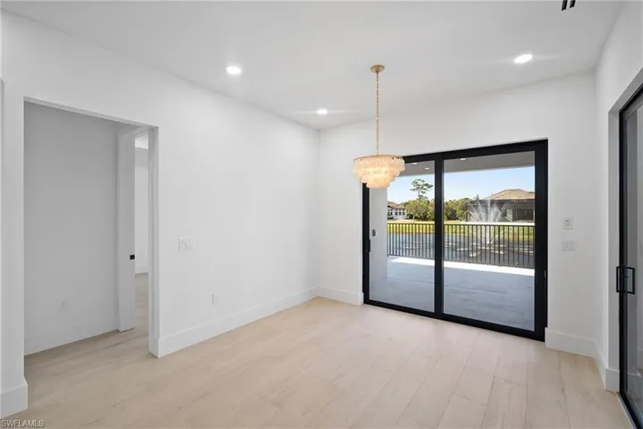 Spare room featuring light wood-type flooring and a chandelier
