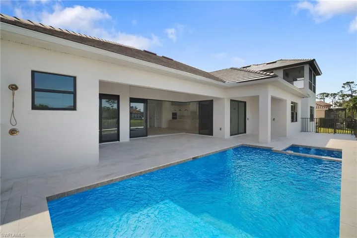 View of swimming pool with an in ground hot tub and a patio area
