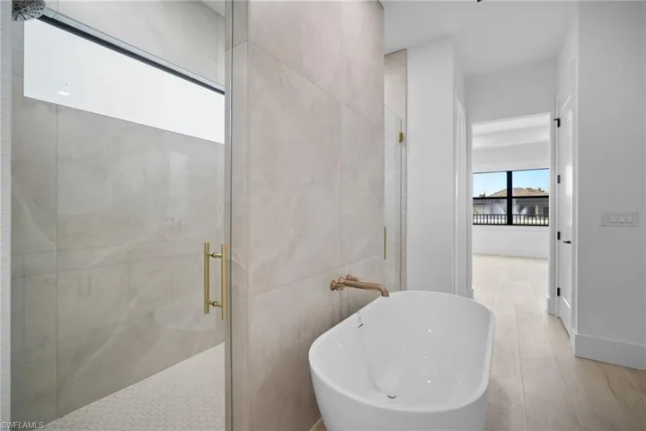 Bathroom featuring plus walk in shower and hardwood / wood-style flooring