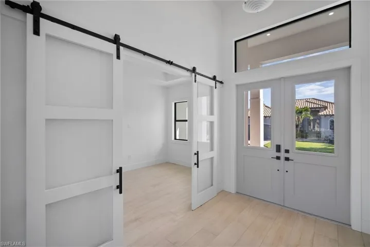 Foyer entrance with french doors and light hardwood / wood-style flooring