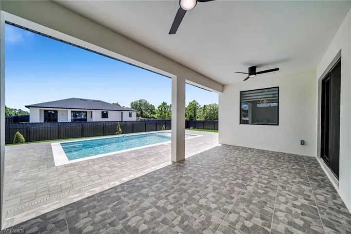 View of swimming pool with a patio area, ceiling fan, and a fenced backyard