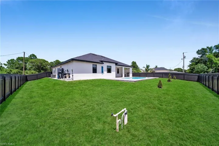 Rear view of house featuring a fenced backyard, a patio area, and stucco siding