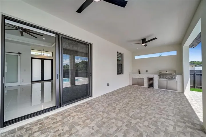 View of patio / terrace featuring ceiling fan, an outdoor kitchen, and beverage cooler