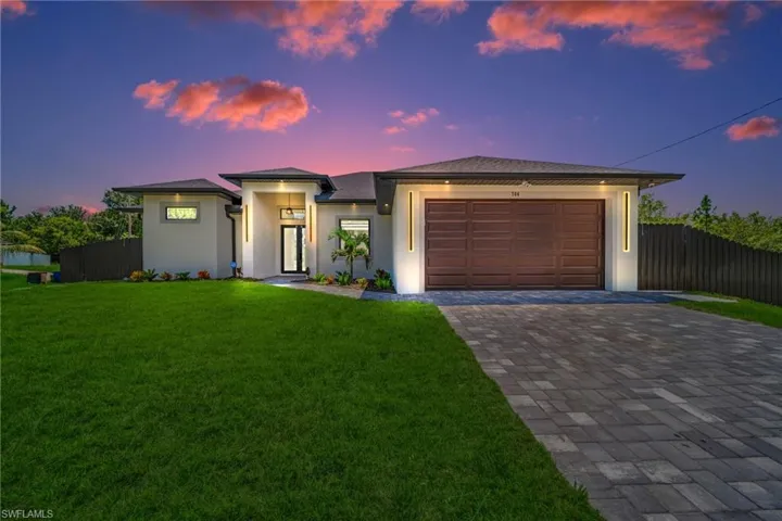 Prairie-style home featuring a garage, decorative driveway, and stucco siding