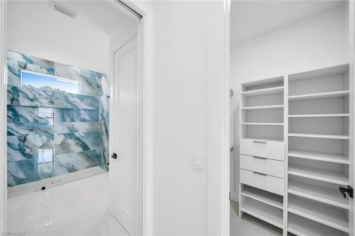 Bathroom featuring a stall shower and a closet