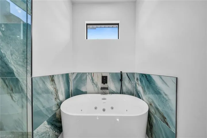 Full bathroom featuring a freestanding bath and tile walls