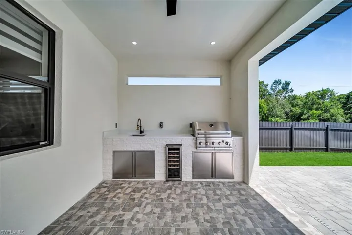 View of patio with an outdoor kitchen and beverage cooler