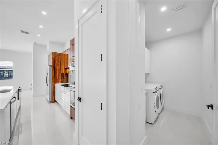Laundry room with independent washer and dryer, recessed lighting, and cabinet space