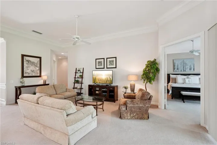 Carpeted living room with ceiling fan, ornamental molding, and recessed lighting