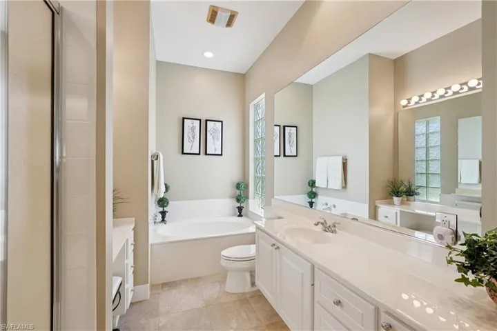 Full bathroom with vanity, a garden tub, a shower stall, light tile patterned floors, and recessed lighting