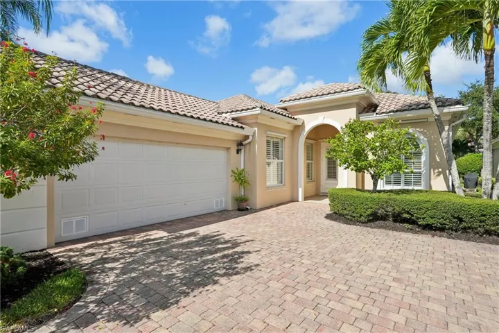 Mediterranean / spanish house featuring stucco siding, decorative driveway, a tiled roof, and a garage