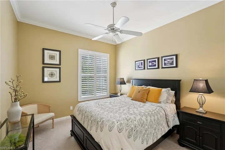 Bedroom featuring ornamental molding, light carpet, and ceiling fan