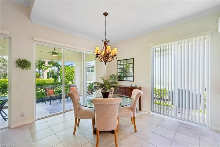 Dining space with crown molding, plenty of natural light, a chandelier, and light tile patterned flooring