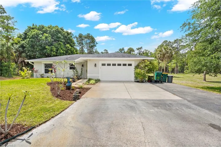 Single-story residence featuring a white exterior and an attached garage with a panel door