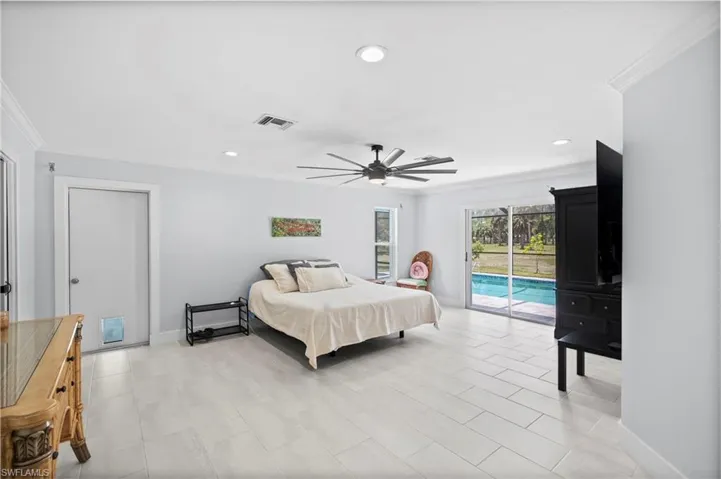 Spacious interior featuring light-toned plank flooring, crown molding, and recessed lighting