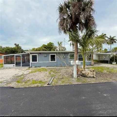 View of front facade with a carport and a sunroom