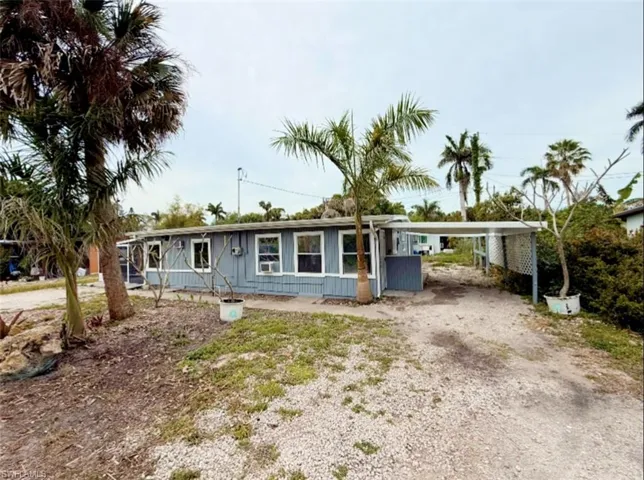 View of front of house with driveway and a carport