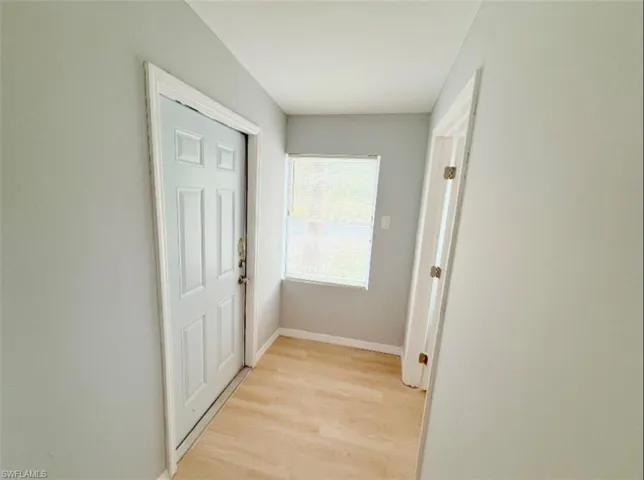 Corridor with light wood finished floors and baseboards