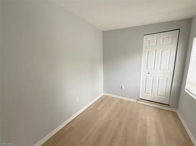 Unfurnished bedroom with light wood-style flooring and baseboards