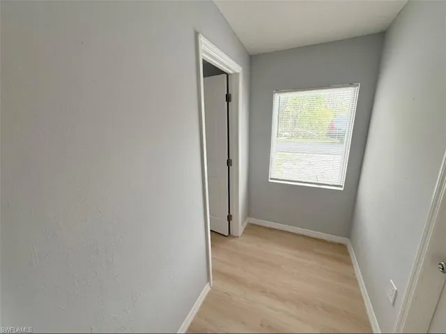 Hall with baseboards and light wood-style floors