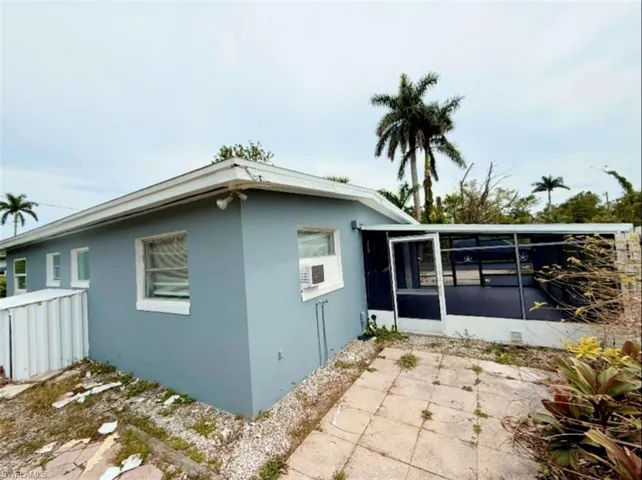 View of home's exterior with stucco siding and a sunroom