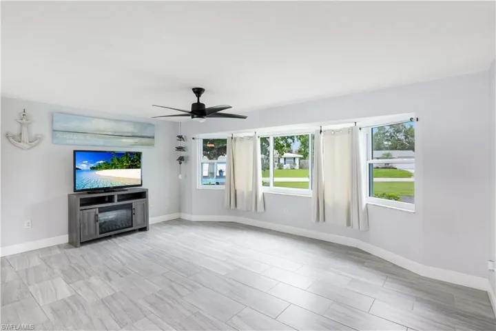 Unfurnished living room featuring ceiling fan