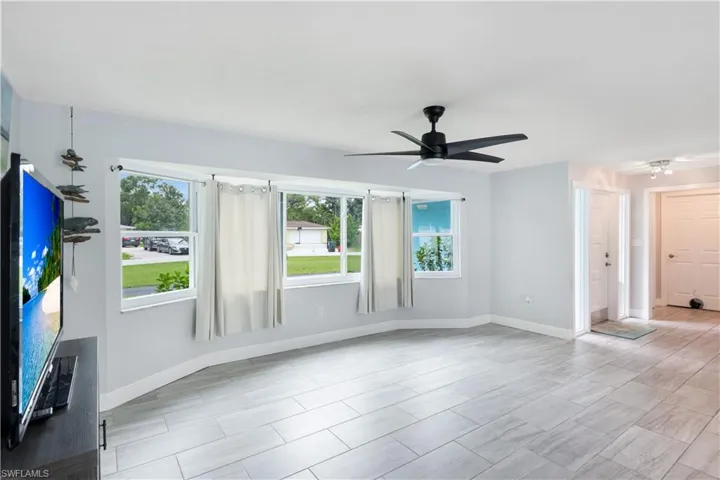 Unfurnished living room featuring ceiling fan and light tile patterned flooring