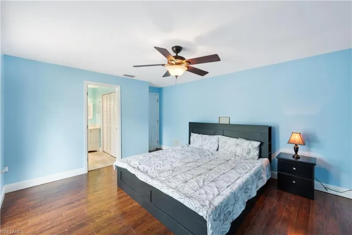 Bedroom with ceiling fan, hardwood / wood-style flooring, and connected bathroom