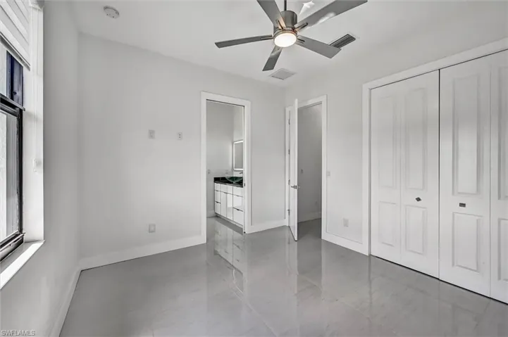 Room featuring light-toned tile flooring, a modern ceiling fan, and white walls