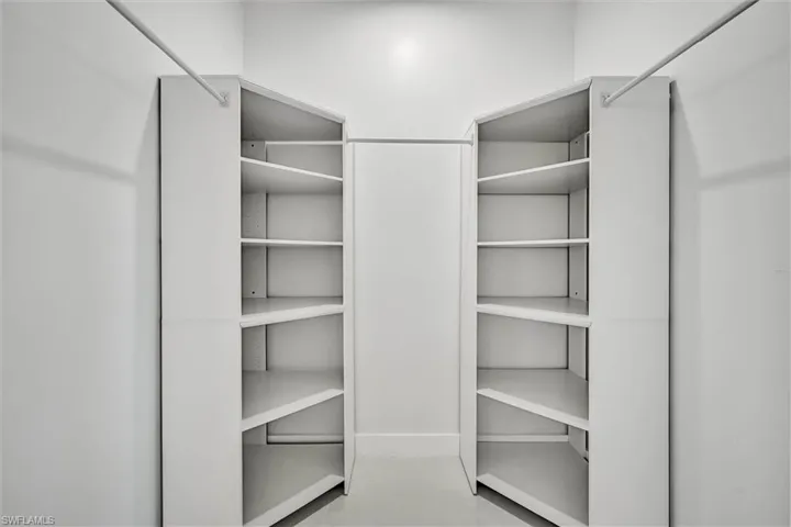 Custom closet system featuring white shelving units and hanging rods