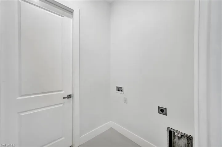 Dedicated utility space featuring white walls and baseboards
