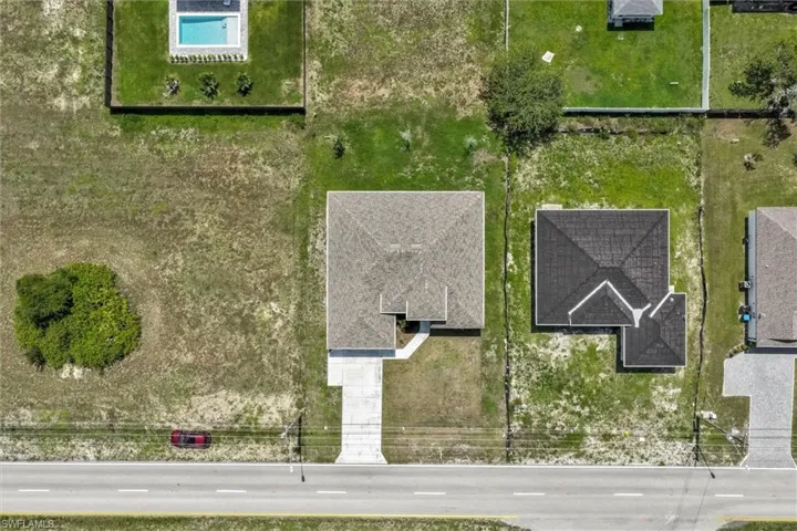 Newly constructed residence featuring a gray shingle roof and a concrete driveway