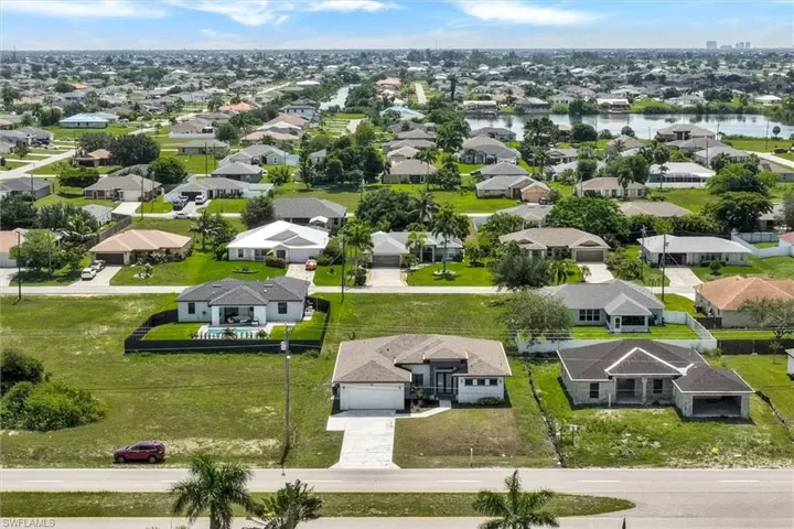 Residential neighborhood featuring a variety of single-story homes, mature landscaping, and a visible canal system
