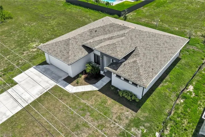 Single-story residence featuring a gray asphalt shingle roof and a concrete driveway