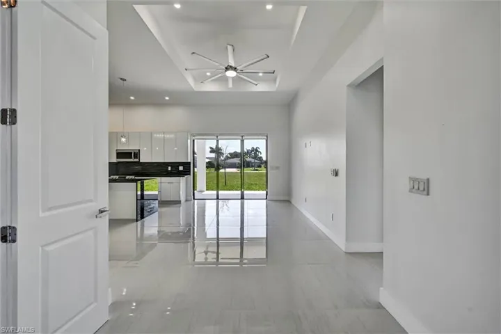 Two-story foyer featuring double entry doors, a transom window, and a chandelier