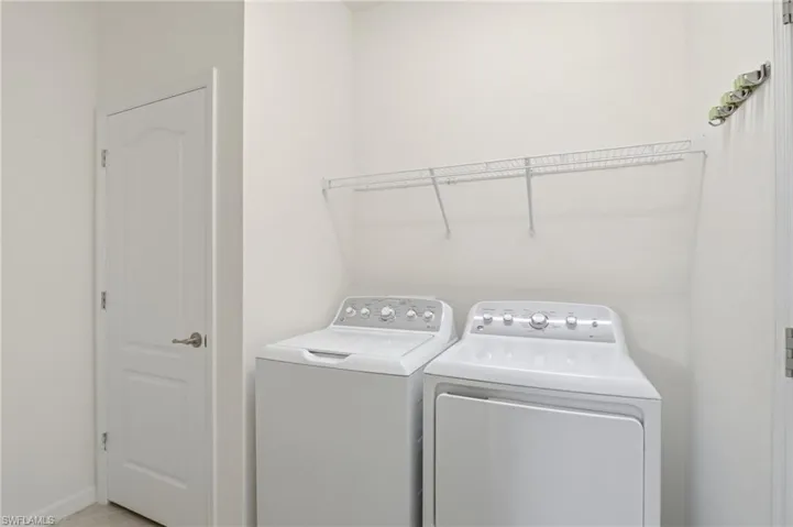 Laundry room featuring separate washer and dryer and light tile patterned floors