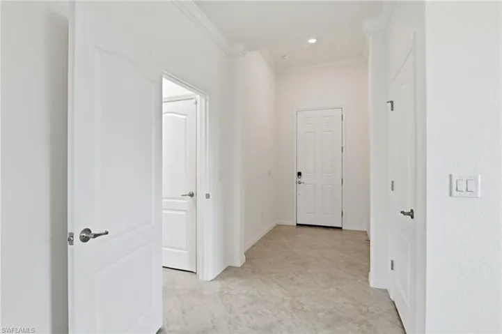 Hallway with crown molding and recessed lighting