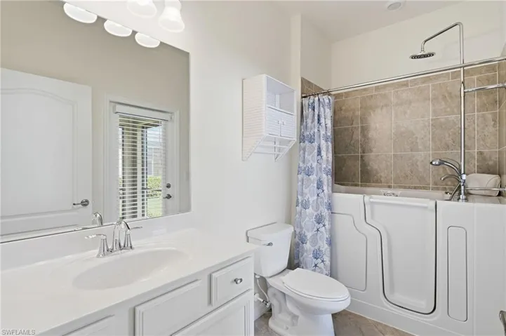Bathroom featuring vanity and shower / tub combo with curtain