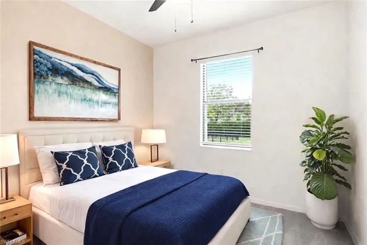 Carpeted bedroom with baseboards and a ceiling fan