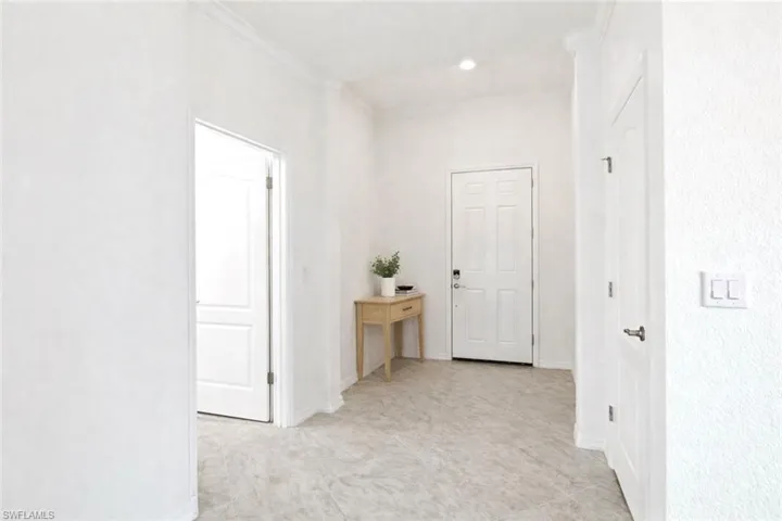 Hallway featuring ornamental molding and baseboards