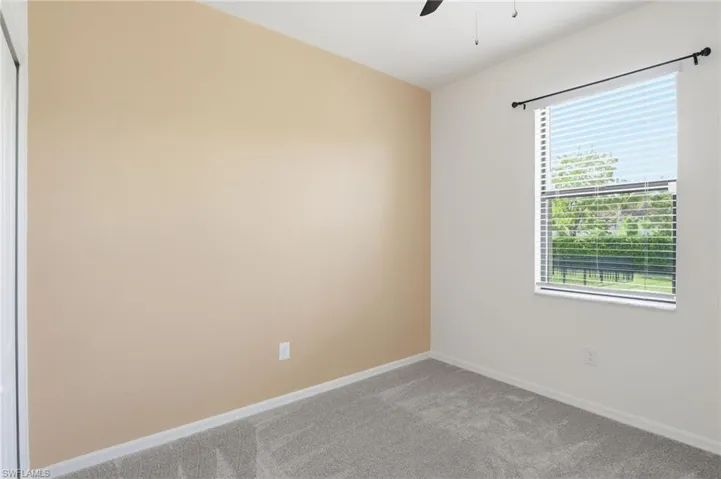 Unfurnished room featuring carpet flooring and ceiling fan