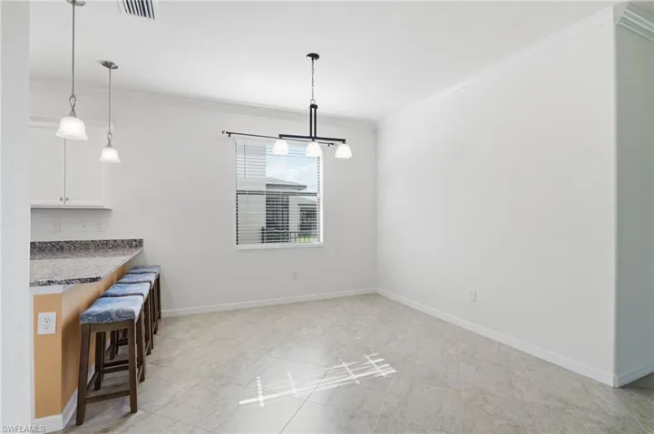 Unfurnished dining area featuring crown molding and baseboards