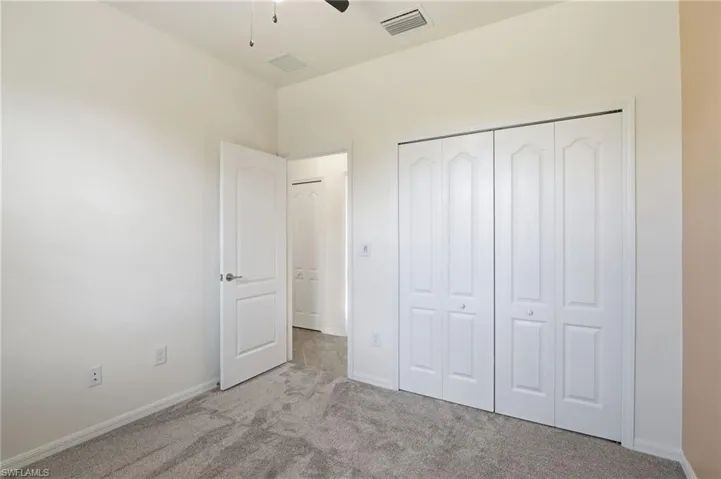 Unfurnished bedroom with carpet, a ceiling fan, and a closet