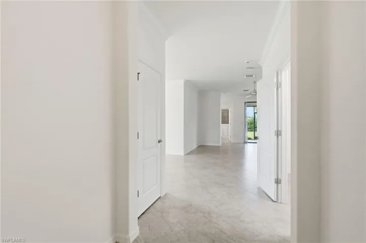 Hallway featuring ornamental molding and baseboards