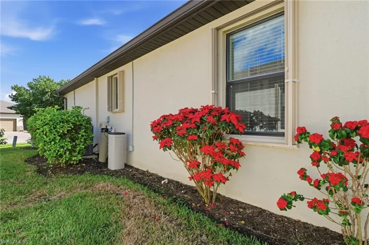 View of side of property featuring stucco siding and a lawn