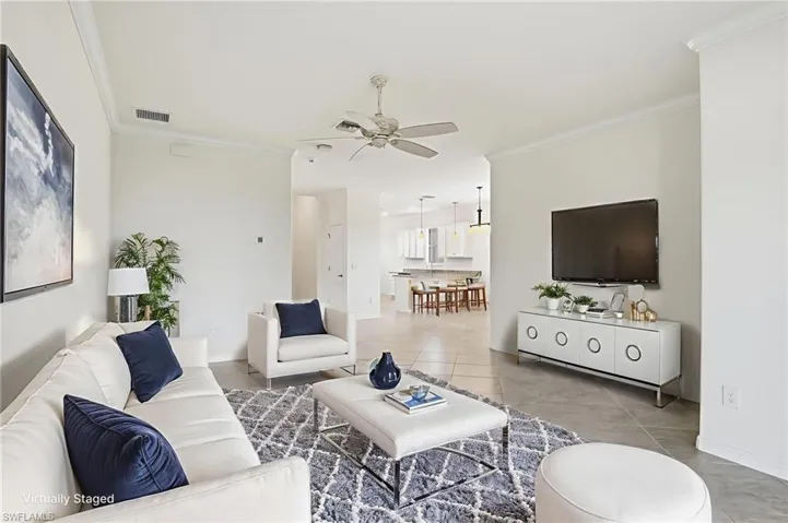 Tiled living room featuring ornamental molding and ceiling fan